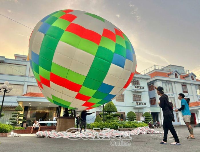  Kỹ thuật viên Công ty Cổ phần Đầu tư xuất nhập khẩu Thương mại Dịch vụ Sài Gòn Chiến Thắng thi công, lắp dựng mô hình khinh khí cầu trang trí mặt đất.