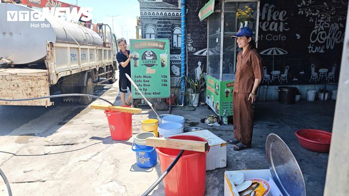 Người dân mang xô, chậu ra trước nhà để hứng nước sạch sinh hoạt và rửa đống bát đũa đang chờ 