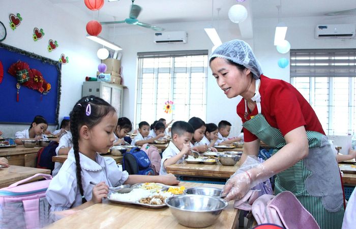Chuẩn bị bữa ăn trưa cho học sinh Trường Tiểu học Cao Bá Quát (xã Thuận An). Ảnh Tiến Thành
