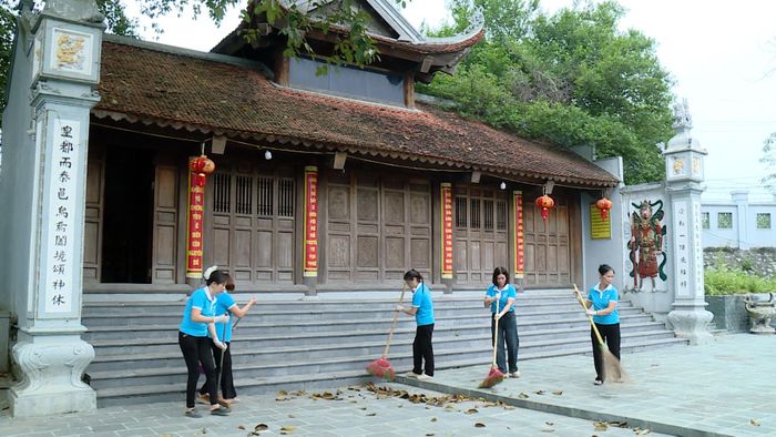 Hội viên phụ nữ xã Ô Diên vệ sinh, chăm sóc cảnh quan tại điểm di tích, góp phần gìn giữ không gian văn hóa sạch đẹp. Ảnh: Đỗ Duẩn