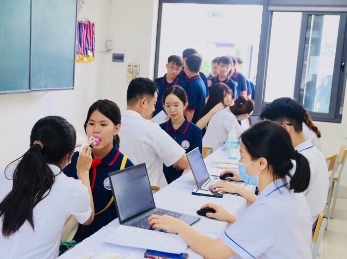 Tại các trường học, việc rà soát danh sách đối tượng đảm bảo rõ ràng, chính xác; đồng thời chuẩn bị địa điểm, nhân lực và điều kiện cần thiết, vận động học sinh tham gia đầy đủ; mỗi dây chuyền khám tại trường bố trí 2 giáo viên sử dụng thành thạo máy tính để tham gia nhập dữ liệu hồ sơ sức khỏe, phối hợp cùng đội ngũ y tế. Ảnh: PV