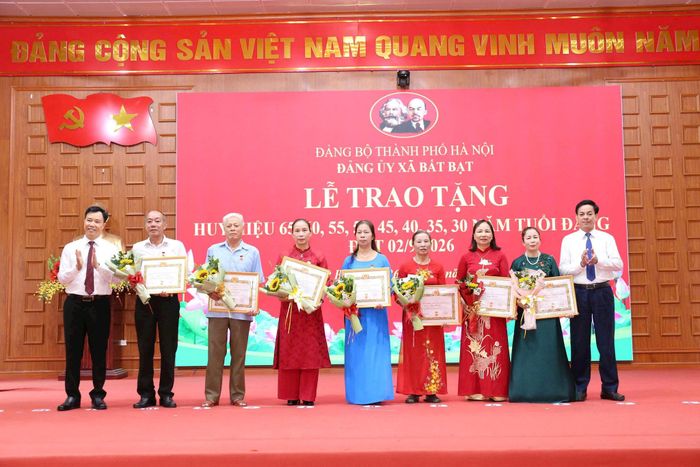 Phó Bí thư Thường trực Đảng ủy xã Bất Bạt Đỗ Anh Sơn trao Huy hiệu Đảng tặng các đảng viên. Ảnh: Khương Tuấn