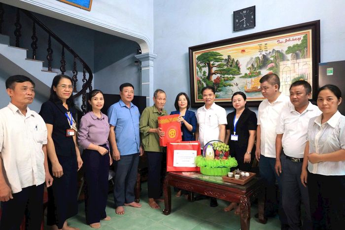 Phó Bí thư thường trực Đảng uỷ xã Thường Tín Trần Hồng Hạnh hỏi thăm sức khỏe, động viên người hoạt động kháng chiến trên địa bàn. Ảnh: PV