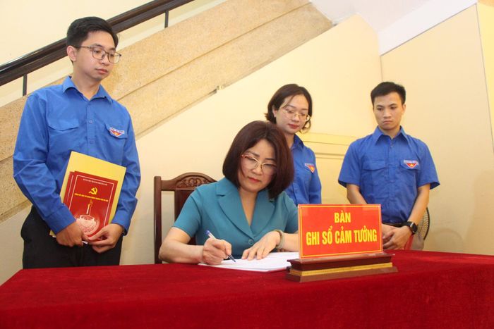 Phó Bí thư Đảng ủy các cơ quan Đảng thành phố Hà Nội Phạm Thị Nguyên Hạnh ghi sổ cảm tưởng tại di tích ngôi nhà số 48 phố Hàng Ngang. Ảnh: MH