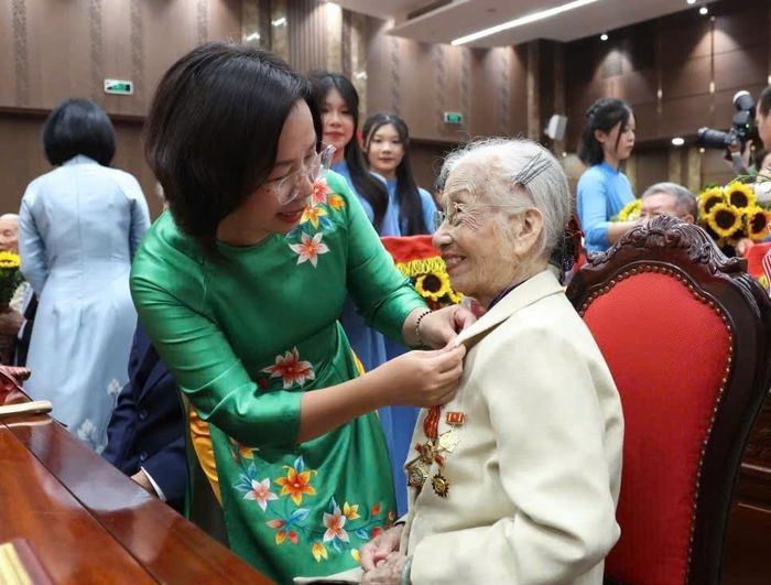 Chủ tịch Ủy ban Mặt trận Tổ quốc Việt Nam thành phố Hà Nội Bùi Huyền Mai gắn Huy hiệu Đảng tặng đảng viên. Ảnh: Nhóm phóng viên