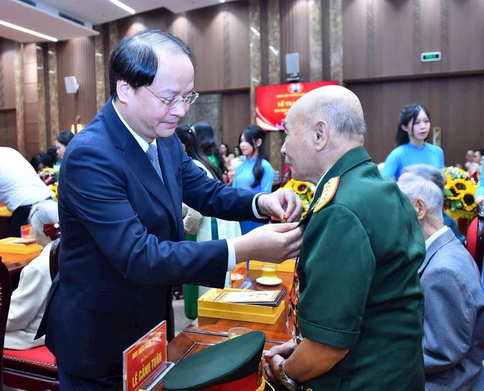 Trưởng ban Tuyên giáo và Dân vận Thành ủy Hà Nội Nguyễn Doãn Toản gắn Huy hiệu Đảng tặng đảng viên. Ảnh: Nhóm phóng viên