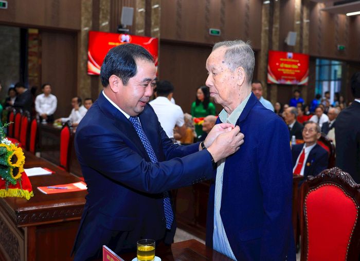 Bí thư Thành ủy Hà Nội Trần Đức Thắng gắn Huy hiệu Đảng tặng đảng viên. Ảnh: Nhóm phóng viên