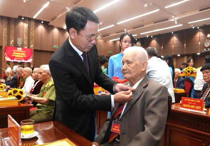Phó Bí thư Thường trực Thành ủy Hà Nội Nguyễn Trọng Đông gắn Huy hiệu Đảng tặng đảng viên. Ảnh: Nhóm phóng viên