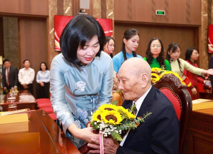 Phó Bí thư Thành ủy, Chủ tịch HĐND thành phố Hà Nội Phùng Thị Hồng Hà tặng hoa chúc mừng đảng viên được tặng Huy hiệu Đảng. Ảnh: Nhóm phóng viên