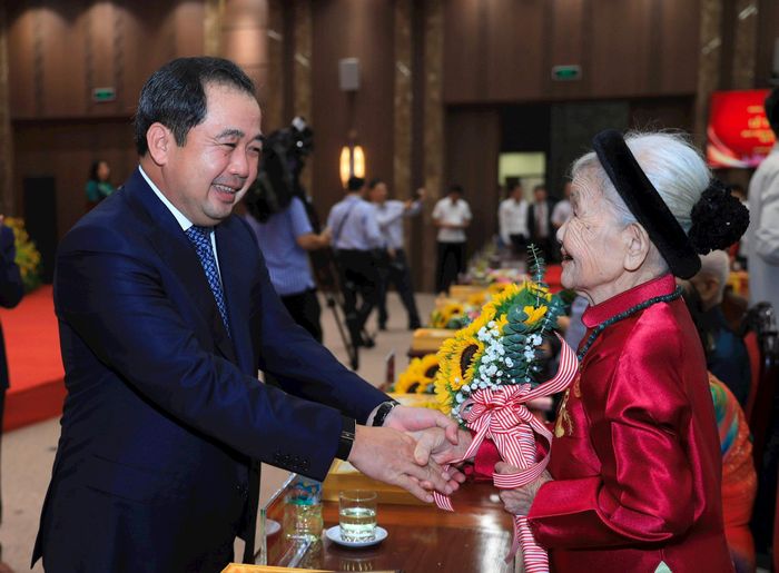 Bí thư Thành ủy Hà Nội Trần Đức Thắng tặng hoa chúc mừng đảng viên được tặng Huy hiệu Đảng. Ảnh: Nhóm phóng viên