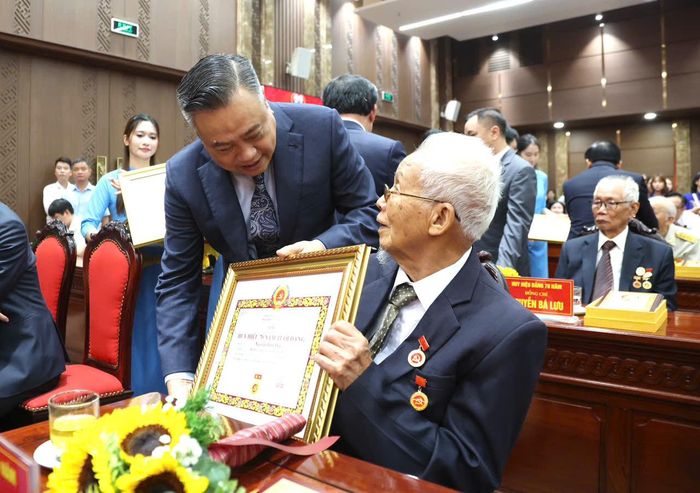 Chủ nhiệm Ủy ban Kiểm tra Trung ương Trần Sỹ Thanh trao Huy hiệu Đảng tặng đảng viên. Ảnh: Nhóm phóng viên