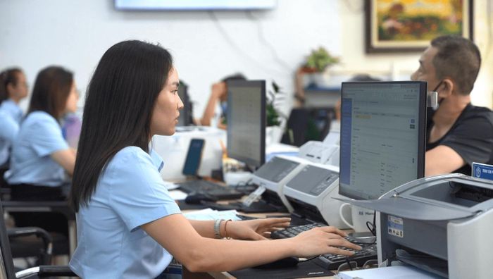 Bà Hoàng Bích Ngọc, Điểm trưởng Điểm hỗ trợ dịch vụ công số phường Tùng Thiện đang giải quyết các thủ tục cho người dân. Ảnh Đ. Đạt