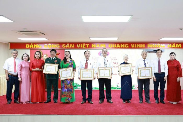 Phó Bí thư thường trực Đảng ủy Nguyễn Sĩ Hoạt và Chủ tịch Ủy ban Mặt trận Tổ quốc phường Dương Nội Lại Hà Phương trao Huy hiệu Đảng tặng đảng viên. Ảnh Thu Oanh