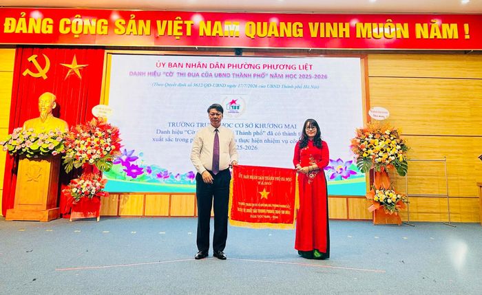 Bí thư Đảng ủy, Chủ tịch HĐND phường Phương Liệt Nguyễn Minh Tiến thừa ủy quyền, trao tặng Cờ thi đua thành phố cho Trường THCS Khương Mai vì có thành tích xuất sắc trong thực hiện nhiệm vụ năm học 2025-2026. Ảnh: NT
