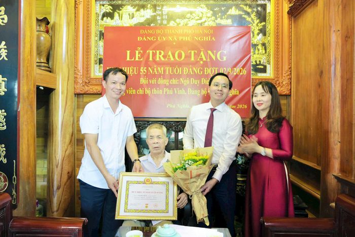 Bí thư Đảng ủy, Chủ tịch HĐND xã Phú Nghĩa Trịnh Tiến Tường trao Huy hiệu 55 tuổi Đảng cho đồng chí Ngô Duy Đích. Ảnh; Hoàng Anh