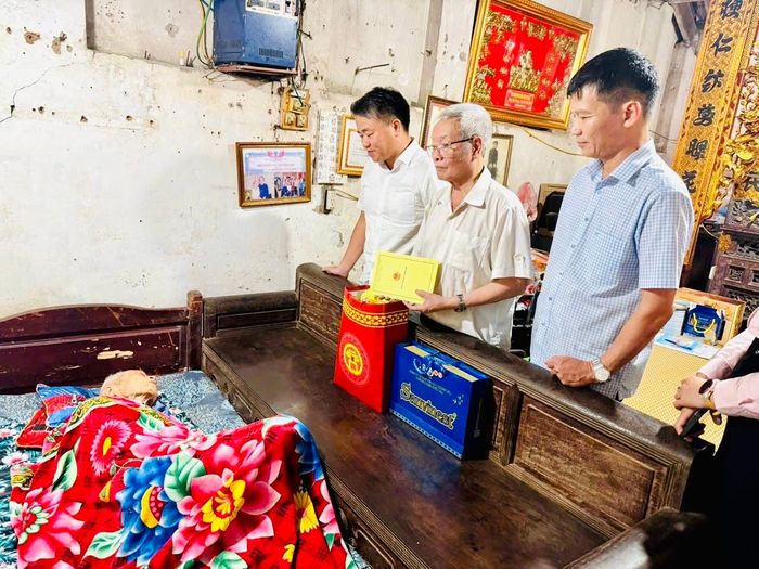 Đại diện lãnh đạo phường Hoàng Mai thăm hỏi, tặng quà và chúc sức khỏe cụ Nguyễn Văn Úc - cán bộ bị địch bắt tù, đày. Ảnh: Tuyết Thanh.
