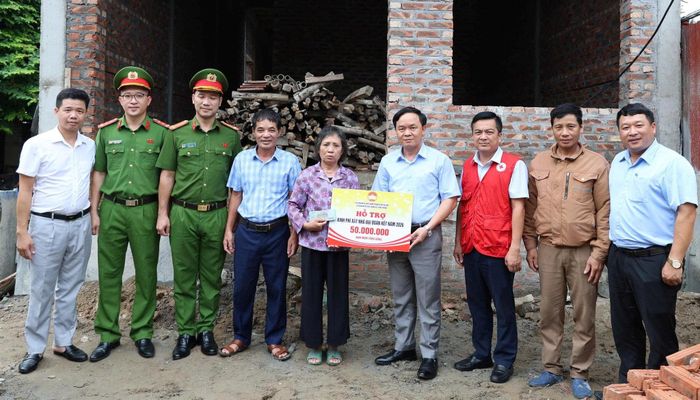 Đoàn công tác trao kinh phí hỗ trợ xây nhà Đại đoàn kết tại thôn Yên Bài. Ảnh PV
