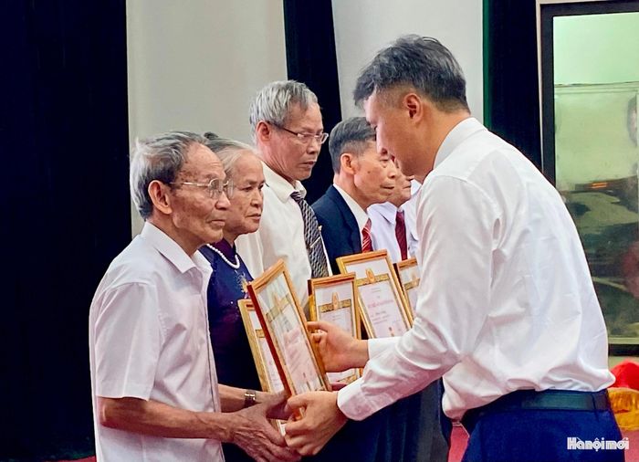 Bí thư Đảng uỷ xã Vĩnh Thanh Nguyễn Anh Dũng trao Huy hiệu 60 tuổi Đảng tặng đảng viên Nguyễn Hữu Khả. Ảnh: Thảo Hương
