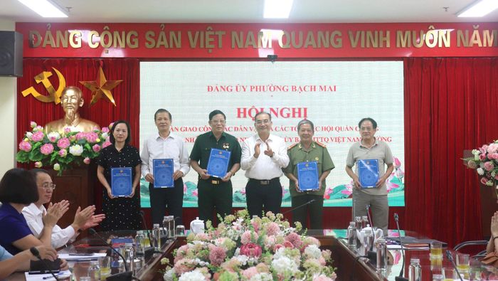 Phó Bí thư Thường trực Đảng ủy phường Bạch Mai Nguyễn Ngọc Phương trao quyết định chuyển giao các Hội do Đảng, Nhà nước giao nhiệm vụ về trực thuộc Ủy ban MTTQ Việt Nam phường. Ảnh: PV
