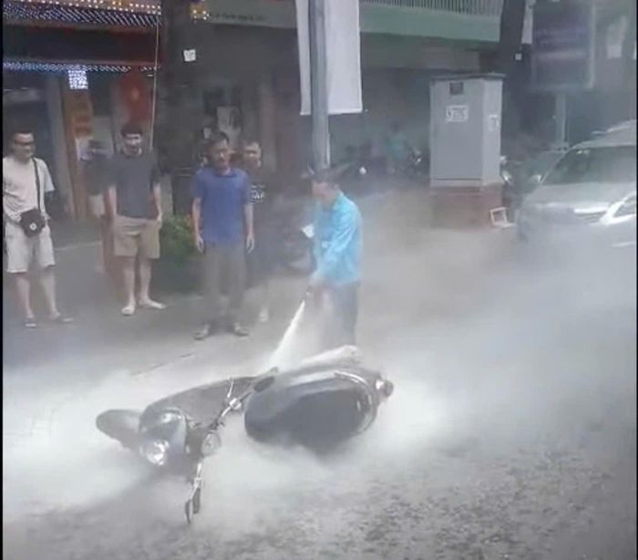 Nhân viên xe buýt tuyến 12 kịp thời hỗ trợ người dân khống chế đám cháy xe máy trên phố. Ảnh: Cắt từ clip