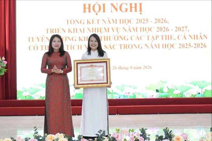 Phó Bí thư Thường trực Đảng ủy xã Trung Giã Nguyễn Thị Kim Tuyến trao Bằng khen của Thủ tướng Chính phủ cho cá nhân thành tích xuất sắc trong năm học 2025-2026. Ảnh: Đức Hiến