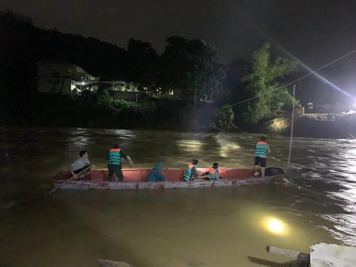 Lực lượng chức năng dùng thuyền vượt dòng nước chảy xiết trong đêm, đưa bệnh nhân qua sông an toàn giữa lúc mưa lũ gây chia cắt. ẢNH: Q.S