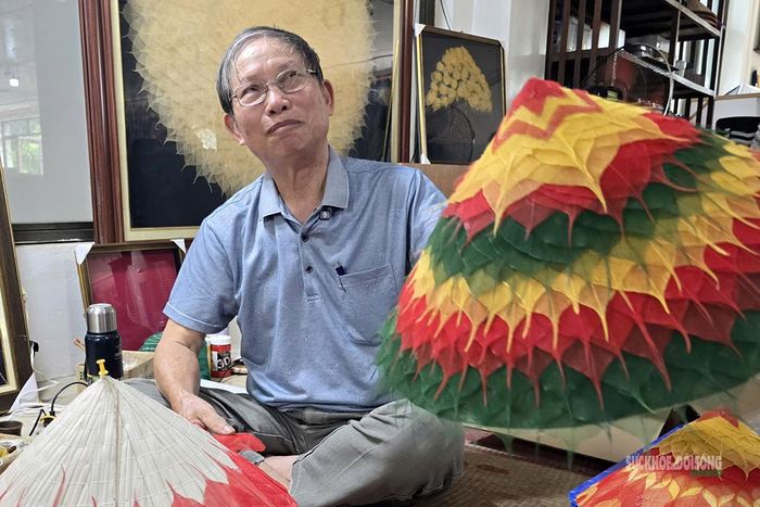 Ông Nguyễn Duy Phương giới thiệu một mẫu nón trang trí bằng lá bồ đề. Ảnh: T.Anh