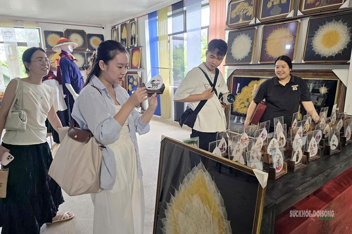 Du khách tham quan, tìm hiểu và lựa chọn các sản phẩm thủ công mỹ nghệ từ lá bồ đề tại Hợp tác xã Sinh Dược. Ảnh: T.Anh