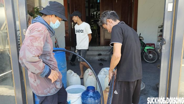 Anh Luân (áo đen) tranh thủ tích trữ nước để phục vụ sinh hoạt. Ảnh: H.D.