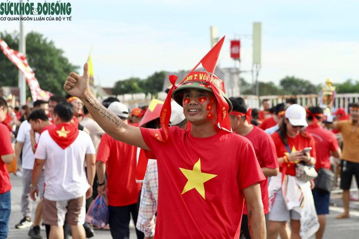 Người hâm mộ đội mũ, mặc áo đỏ, cầm cờ và băng rôn, háo hức đổ về sân Mỹ Đình, sẵn sàng tiếp lửa cho đội tuyển Việt Nam trước giờ bóng lăn. (Ảnh Thành Long)