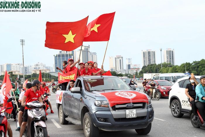 Một nhóm cổ động viên diễu hành qua SVĐ Mỹ Đình bằng xe ô tô. (Ảnh Thành Long)