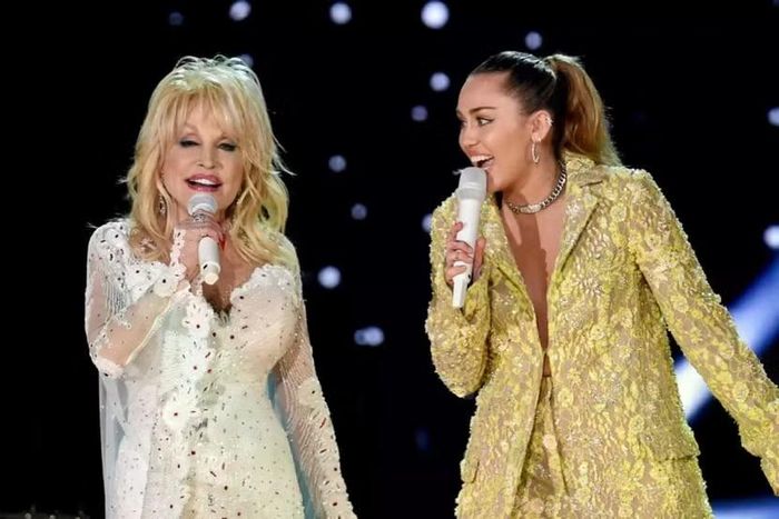 Ca sĩ Miley Cirus và cố ca sĩ Dolly Parton trên cùng một sân khấu (Ảnh: Getty Images).