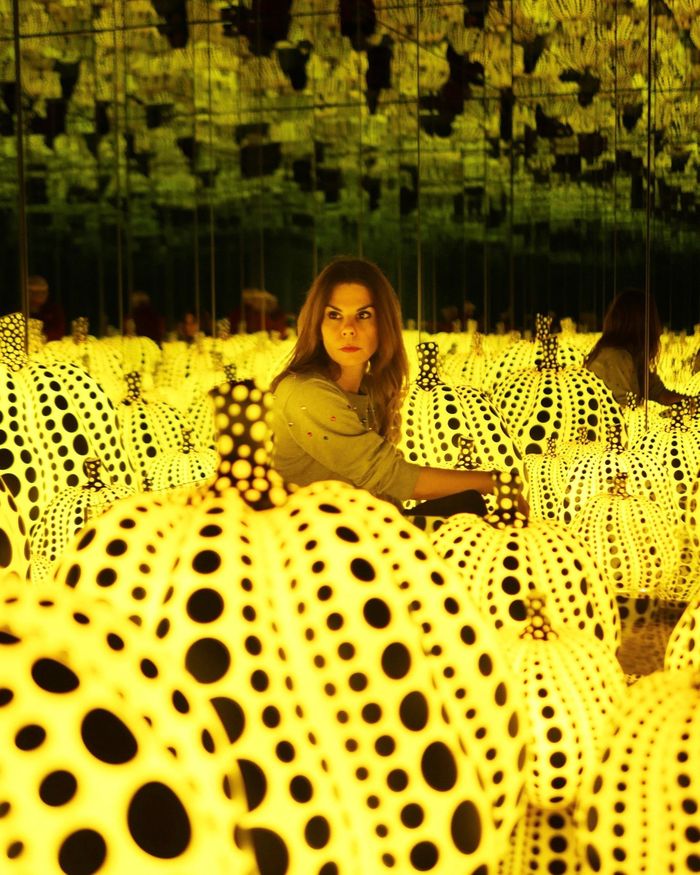 Infinity Mirrored Room - All the Eternal Love I Have for the Pumpkins (tạm dịch: Phòng gương vô cực - Tình yêu vĩnh cửu dành cho những quả bí ngô) ra đời năm 2016, kết hợp hai hình ảnh nổi tiếng nhất trong sự nghiệp Kusama là bí ngô và căn phòng gương. Theo Hirshhorn Museum and Sculpture Garden, Kusama đã yêu thích hình dáng bí ngô từ khi còn nhỏ và đưa motif này vào các bản vẽ từ cuối thập niên 1940, sau đó liên tục sử dụng trong tranh, điêu khắc và nghệ thuật sắp đặt. Trong tác phẩm năm 2016, những quả bí ngô phát sáng mang họa tiết chấm bi được đặt giữa hệ thống gương, tạo nên cảm giác một cánh đồng bí ngô kéo dài vô tận. Ảnh: Maria Brito.