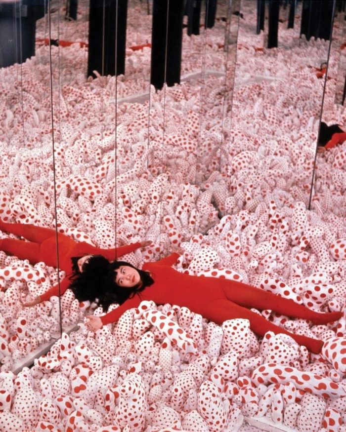 Năm 1965, Kusama thực hiện Infinity Mirror Room-Phalli’s Field (tạm dịch: Phòng vô cực), tác phẩm được bảo tàng Hirshhorn thuộc Viện Smithsonian (Mỹ) xem là một bước đột phá trong sự nghiệp của bà. Bên trong căn phòng là các khối vải mềm phủ chấm đỏ, được bao quanh bởi những tấm gương. Nhờ hiệu ứng phản chiếu, số lượng vật thể hữu hạn dường như được nhân lên vô tận, giúp Kusama đạt được cảm giác lặp lại mà trước đó bà phải tạo thủ công với hàng nghìn chi tiết. Từ tác phẩm này, nữ nghệ sĩ tiếp tục phát triển hơn 20 Infinity Mirror Rooms, đưa người xem bước vào thế giới của ánh sáng, gương và những hình ảnh phản chiếu vô cực. Ảnh: Eikoh Hosoe.