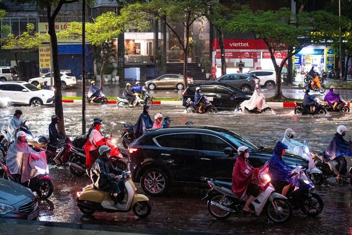  Mực nước dâng cao không quá nửa bánh xe, nhưng nhiều người chọn di chuyển lên vỉa hè một trung tâm thương mại lân cận để đề phòng xe bị chết máy. Ảnh: Đinh Hà. 