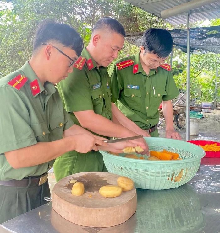 Cán bộ Công an xã Văn Chấn tham gia chuẩn bị nguyên liệu cho bữa cháo nghĩa tình