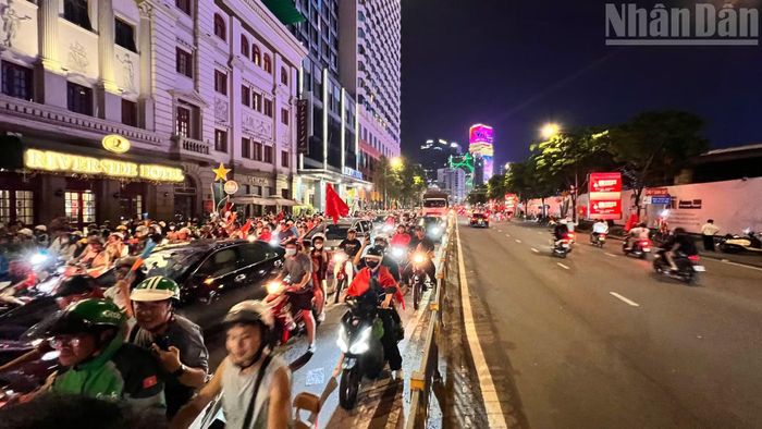 Người hâm mộ Thành phố Hồ Chí Minh hân hoan xuống đường vẫy cờ chúc mừng chiến thắng của đội tuyển bóng đá nam Việt Nam. (Ảnh: Thế Anh)