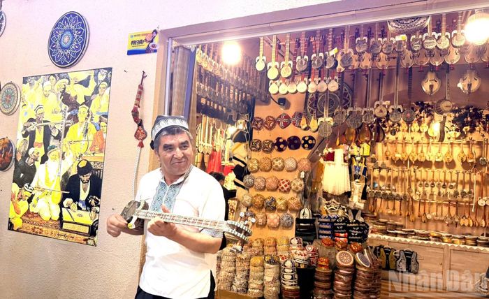 Chủ cửa hàng đàn đang ngẫu hứng chơi những điệu nhạc mang đậm phong cách bản địa. (Ảnh: HỮU HƯNG)