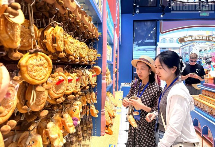 Nữ du khách đang lựa chọn những món đồ lưu niệm ưng ý nhất. (Ảnh: HỮU HƯNG)