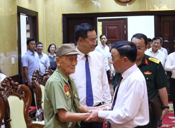 Đồng chí Thường trực Ban Bí thư Trần Cẩm Tú ân cần chúc sức khỏe đảng viên lão thành Hồ Văn Lang.