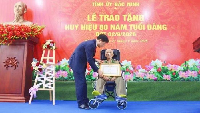 Đồng chí Nguyễn Duy Ngọc trao tặng Huy hiệu 80 năm tuổi Đảng cho đảng viên Đỗ Việt Hưng. (Ảnh: DL)