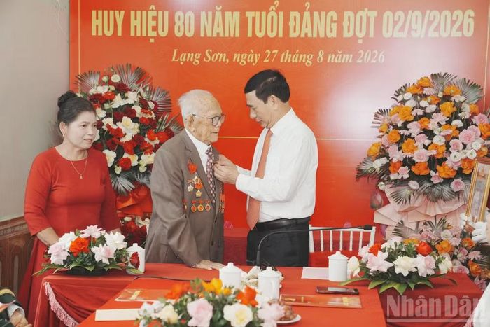 Đại tướng Phan Văn Giang, Ủy viên Bộ Chính trị, Phó Thủ tướng Chính phủ, Bộ trưởng Quốc phòng gắn Huy hiệu 80 năm tuổi Đảng cho đồng chí Hoàng Hai. (Ảnh: QUỐC ĐẠT)