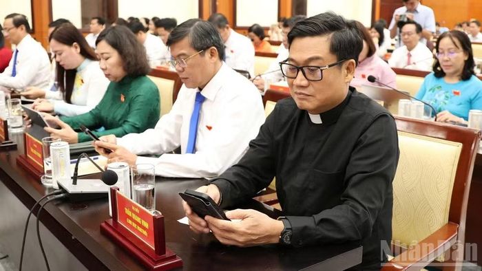 Các đại biểu nhấn nút thông qua Đề án thành lập các phường trên cơ sở nguyên trạng 29 xã trên địa bàn thành phố. (Ảnh: THẾ ANH)