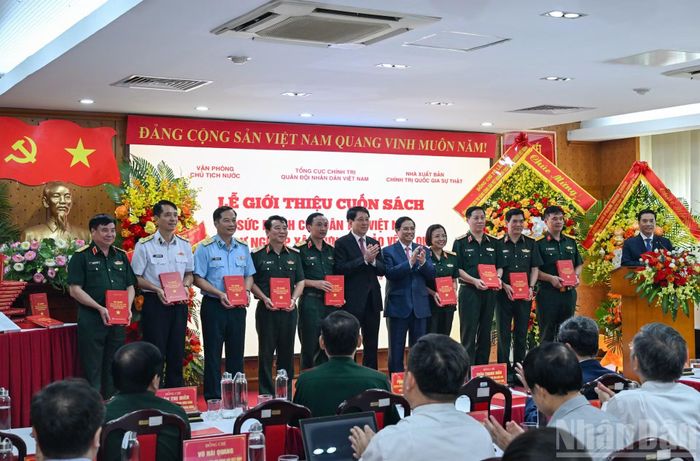 Nguyên Chủ tịch nước Lương Cường, nguyên Thủ tướng Chính phủ Phạm Minh Chính trao sách tặng các đại biểu. (Ảnh: DUY LINH)