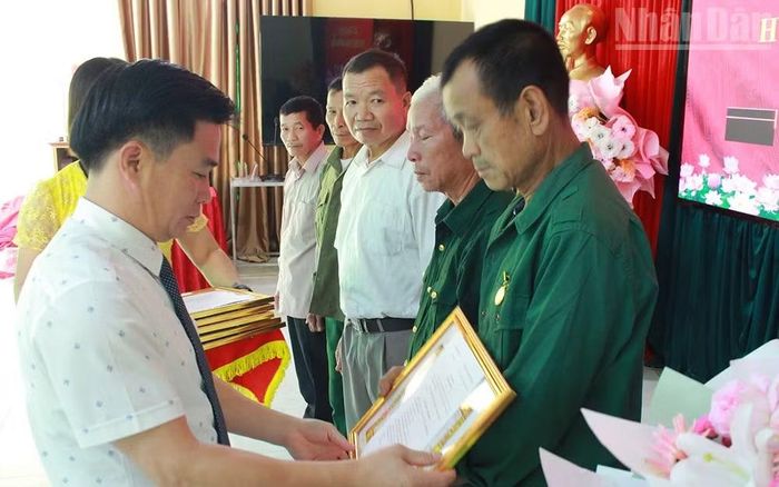 Đồng chí Phan Quý Dương, Bí thư Đảng ủy xã Mường Bang, trao tặng Huy hiệu Đảng﻿ cho các đảng viên. (Ảnh: THÁI BÌNH)
