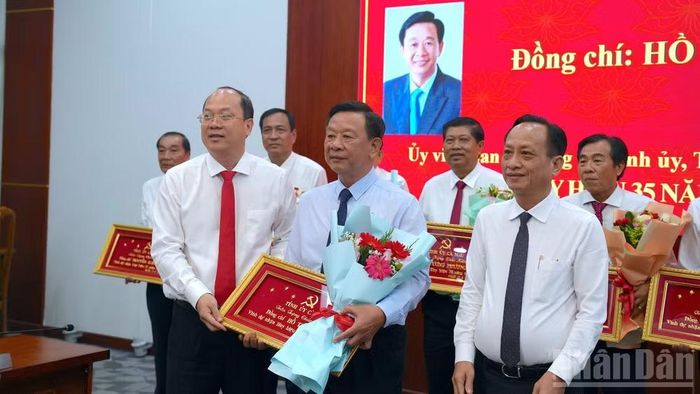 Đồng chí Nguyễn Hồ Hải, Ủy viên Trung ương Đảng, Bí thư Tỉnh ủy Cà Mau (bìa trái) và đồng chí Phạm Văn Thiều, Phó Bí thư, Chủ tịch Hội đồng nhân dân tỉnh (bìa phải) trao Huy hiệu 35 năm tuổi Đảng và Khánh Vàng cho đồng chí Hồ Trung Việt, Trưởng Ban Tuyên giáo Tỉnh ủy Cà Mau (đứng giữa). (ảnh HỮU TÙNG).