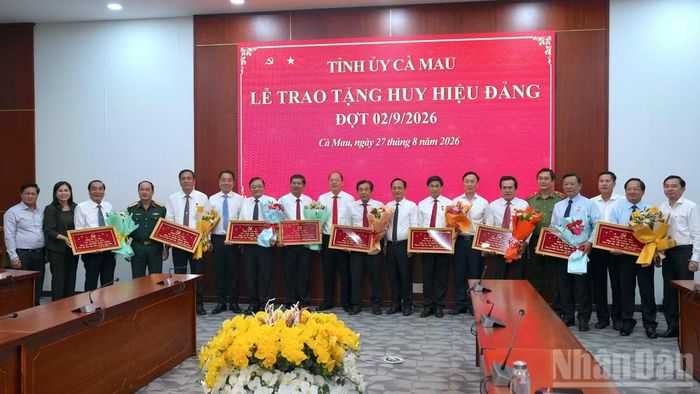 Lãnh đạo Tỉnh ủy Cà Mau chụp ảnh lưu niệm cùng các đồng chí lãnh đạo, nguyên lãnh đạo tỉnh được trao tặng Huy hiệu Đảng đợt 2/9. (ảnh HỮU TÙNG).