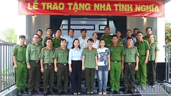 Đại biểu chụp ảnh lưu niệm cùng gia đình và người thân Đại úy Trần Minh Giàu, cán bộ Công an xã Phú Thọ, ngụ ấp Long Thành, xã Phú Thọ, tỉnh Đồng Tháp.(Ảnh: PHƯỚC THANH)