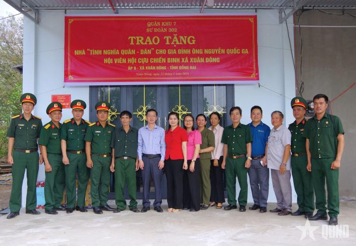 Các đại biểu tại buổi trao nhà tặng cựu chiến binh Nguyễn Quốc Ga (thứ năm, từ trái sang).