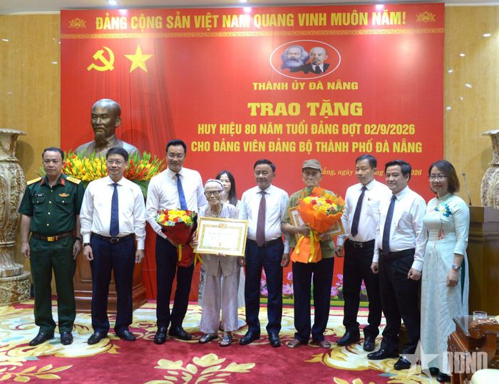 Đồng chí Trần Cẩm Tú trao Huy hiệu 80 năm tuổi Đảng tặng đảng viên Nguyễn Thị Hữu và đảng viên Hồ Văn Lang.